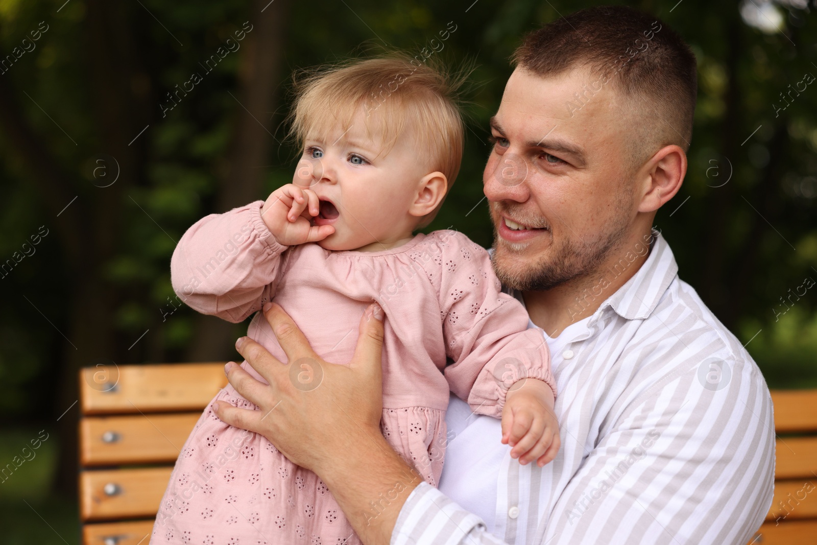 Smiling dad and his newborn girl on bench outdoors. Happy Father's Day Photo of Smiling dad and his newborn girl on bench outdoors. Happy Father's Day