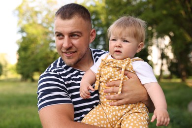 Photo of Smiling dad and his newborn baby outdoors. Happy Father's Day