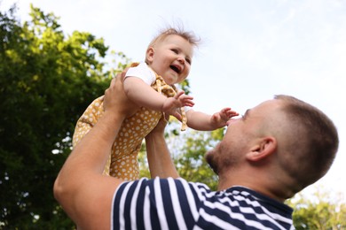 Photo of Dad having fun with his newborn baby outdoors. Happy Father's Day