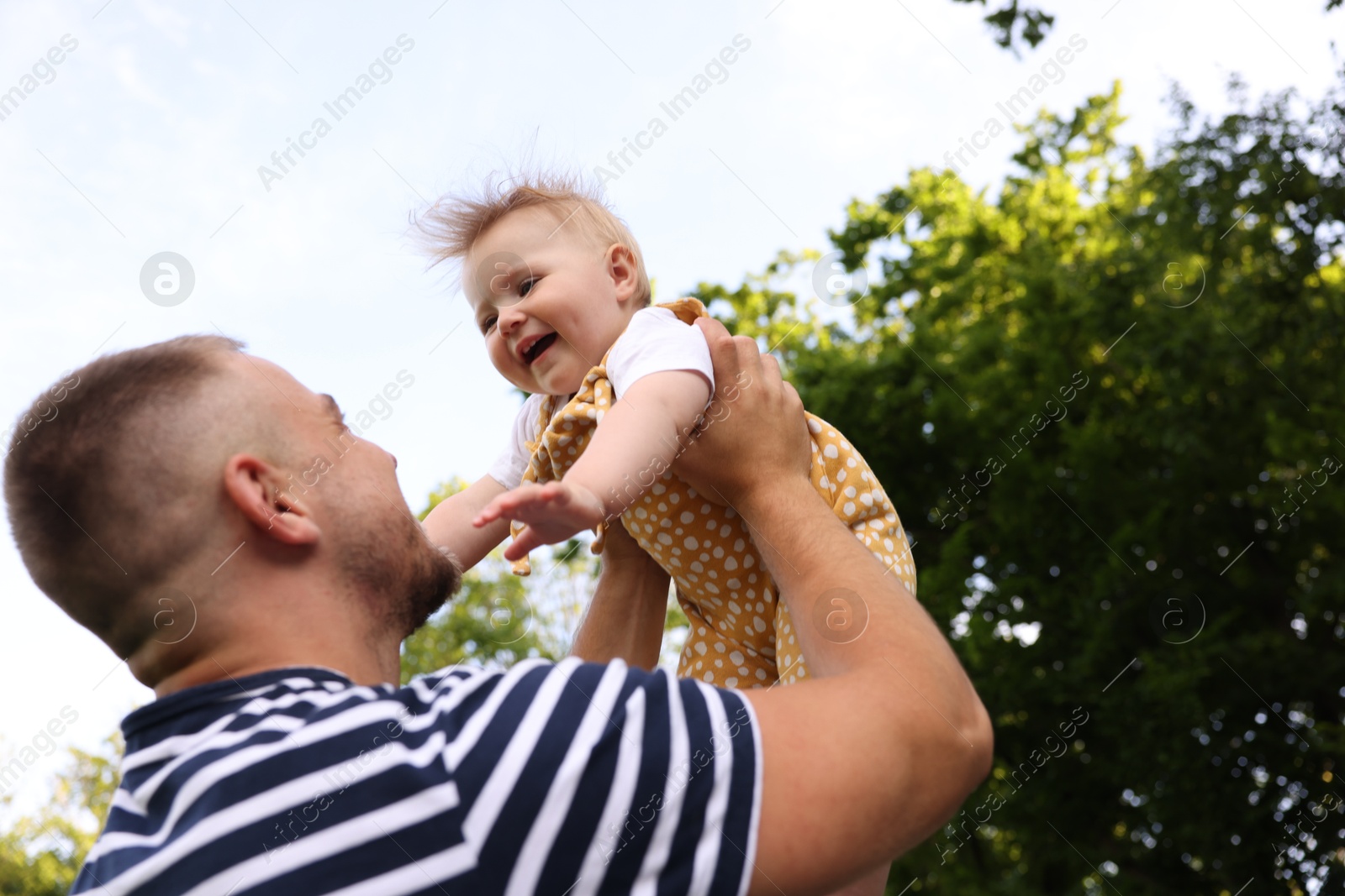 Photo of Dad having fun with his newborn baby outdoors. Happy Father's Day
