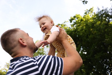 Photo of Dad having fun with his newborn baby outdoors. Happy Father's Day