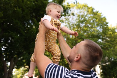 Photo of Dad having fun with his newborn baby outdoors. Happy Father's Day