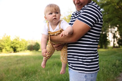 Photo of Smiling dad and his newborn baby outdoors, closeup. Happy Father's Day