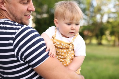 Photo of Smiling dad and his newborn baby outdoors, closeup. Happy Father's Day