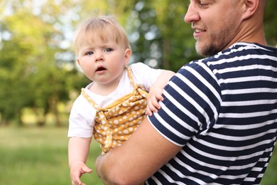 Photo of Smiling dad and his newborn baby outdoors, closeup. Happy Father's Day