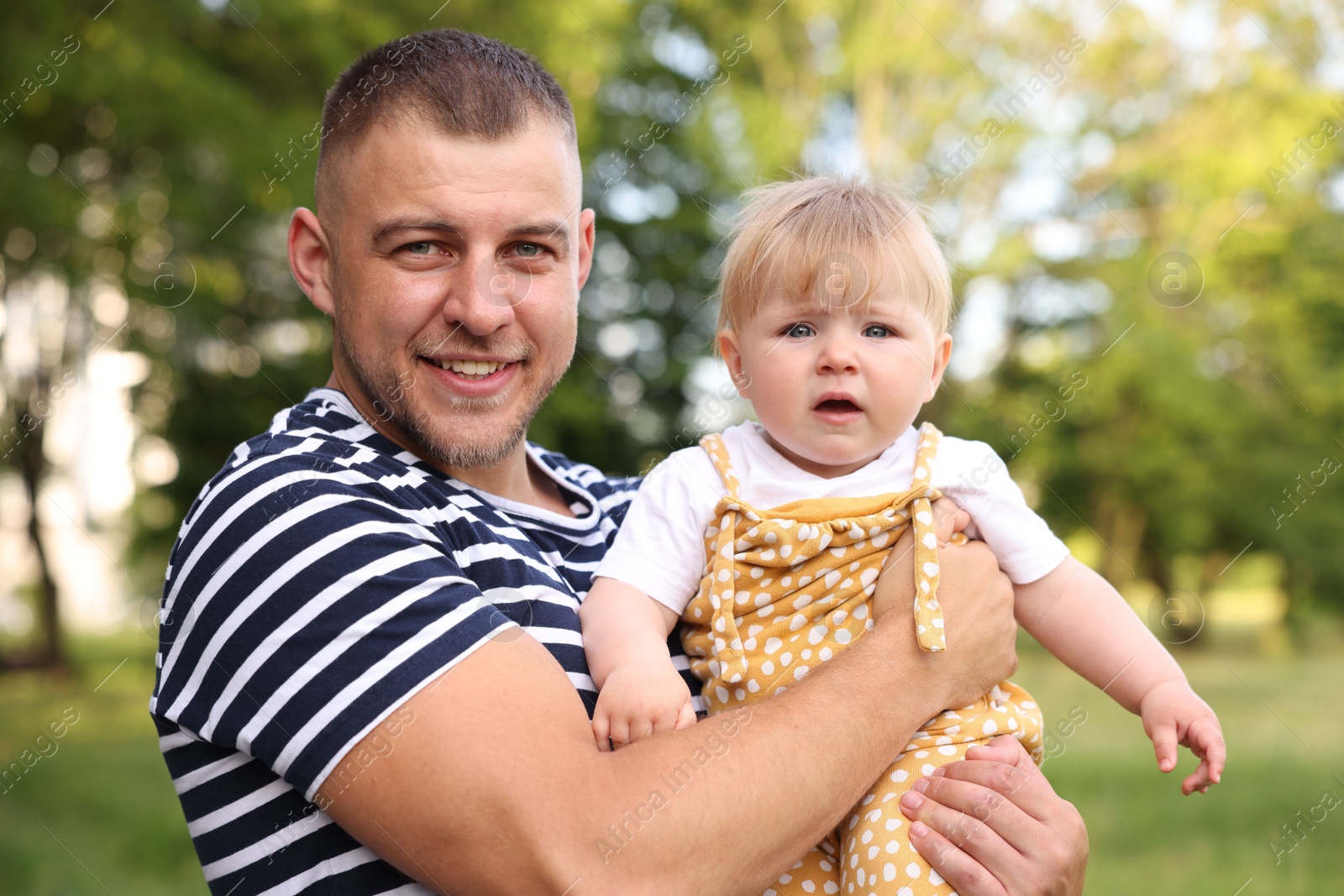 Photo of Smiling dad and his newborn baby outdoors. Happy Father's Day