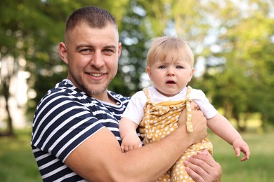 Photo of Smiling dad and his newborn baby outdoors. Happy Father's Day