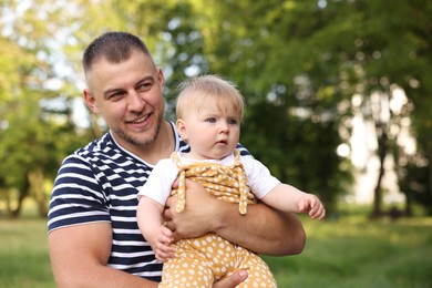 Photo of Smiling dad and his newborn baby outdoors. Happy Father's Day