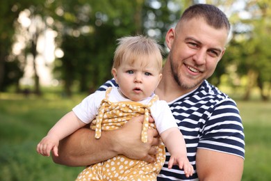 Photo of Smiling dad and his newborn baby outdoors. Happy Father's Day