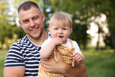 Photo of Smiling dad and his newborn baby outdoors. Happy Father's Day
