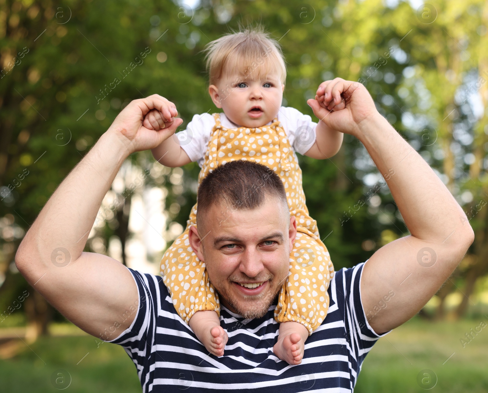 Photo of Smiling dad and his newborn baby playing outdoors. Happy Father's Day