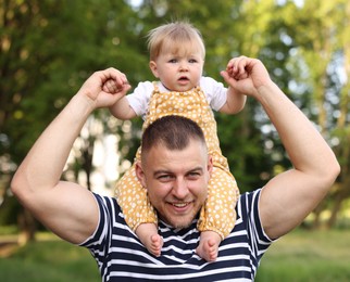 Photo of Smiling dad and his newborn baby playing outdoors. Happy Father's Day