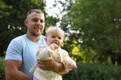 Photo of Smiling dad and his newborn baby outdoors, space for text. Happy Father's Day