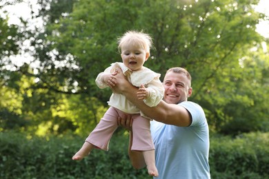 Photo of Smiling dad and his newborn baby playing outdoors. Happy Father's Day