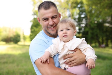 Photo of Smiling dad and his newborn baby outdoors. Happy Father's Day