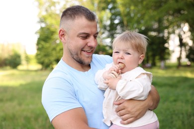 Photo of Smiling dad and his newborn baby outdoors. Happy Father's Day
