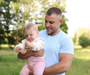 Photo of Smiling dad and his newborn baby outdoors. Happy Father's Day