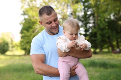Photo of Smiling dad and his newborn baby outdoors. Happy Father's Day
