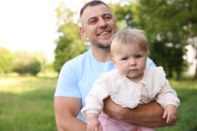 Photo of Smiling dad and his newborn baby outdoors. Happy Father's Day