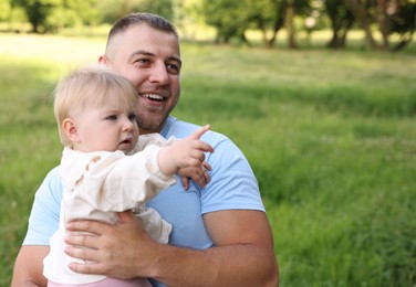Photo of Smiling dad and his newborn baby outdoors. Happy Father's Day
