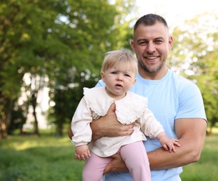 Photo of Smiling dad and his newborn baby outdoors. Happy Father's Day
