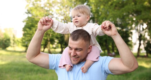 Photo of Smiling dad and his newborn baby playing outdoors. Happy Father's Day