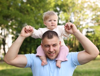Photo of Smiling dad and his newborn baby playing outdoors. Happy Father's Day