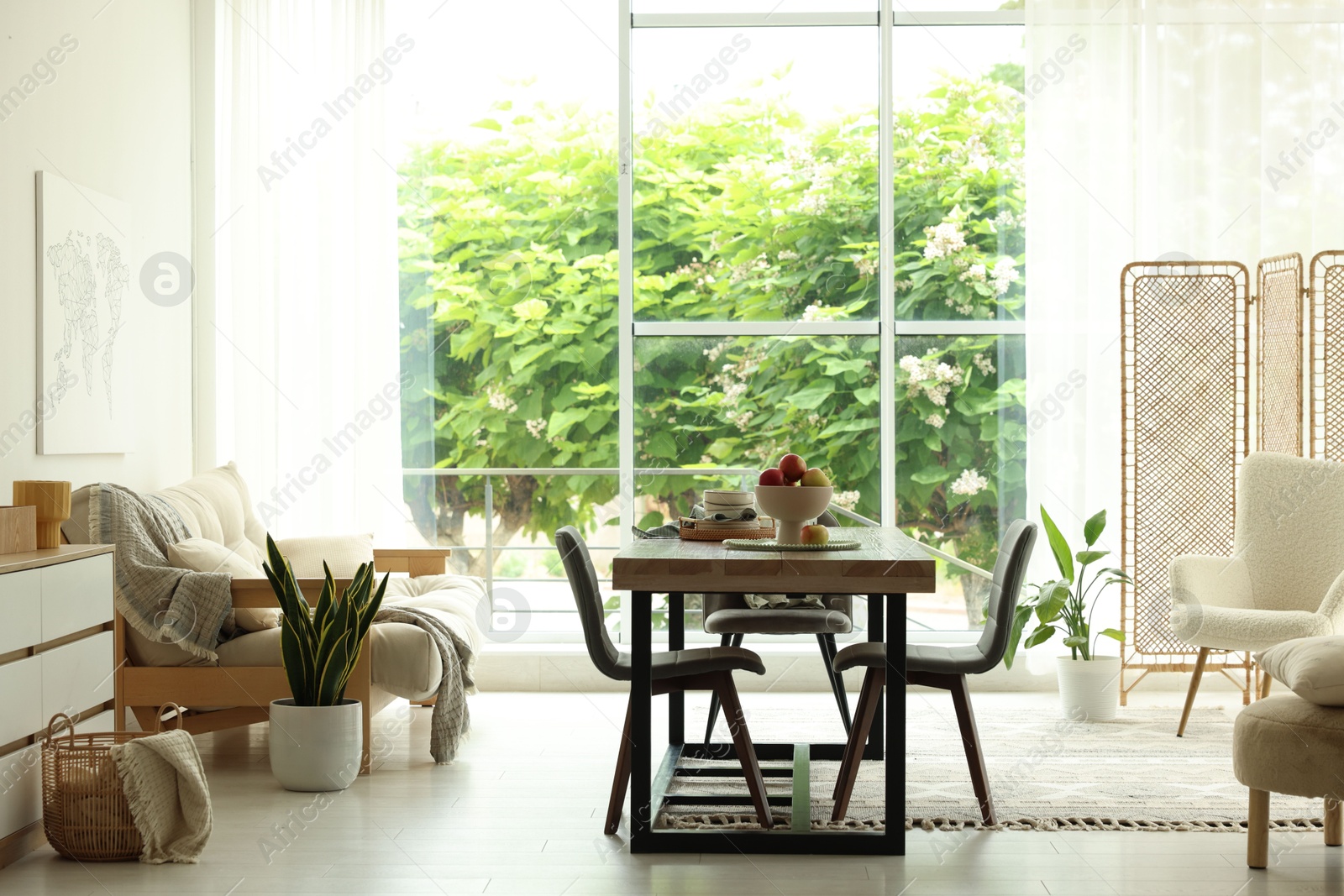 Wooden table, chairs, sofa and decor in dining room. Interior design Photo of Wooden table, chairs, sofa and decor in dining room. Interior design