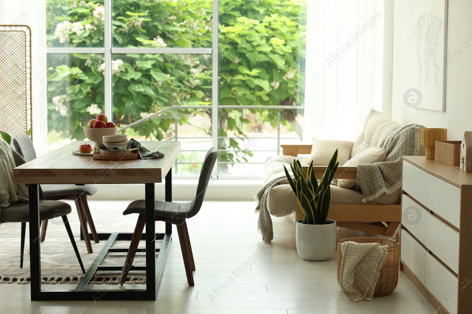 Wooden table, chairs, sofa and decor in dining room. Interior design Photo of Wooden table, chairs, sofa and decor in dining room. Interior design
