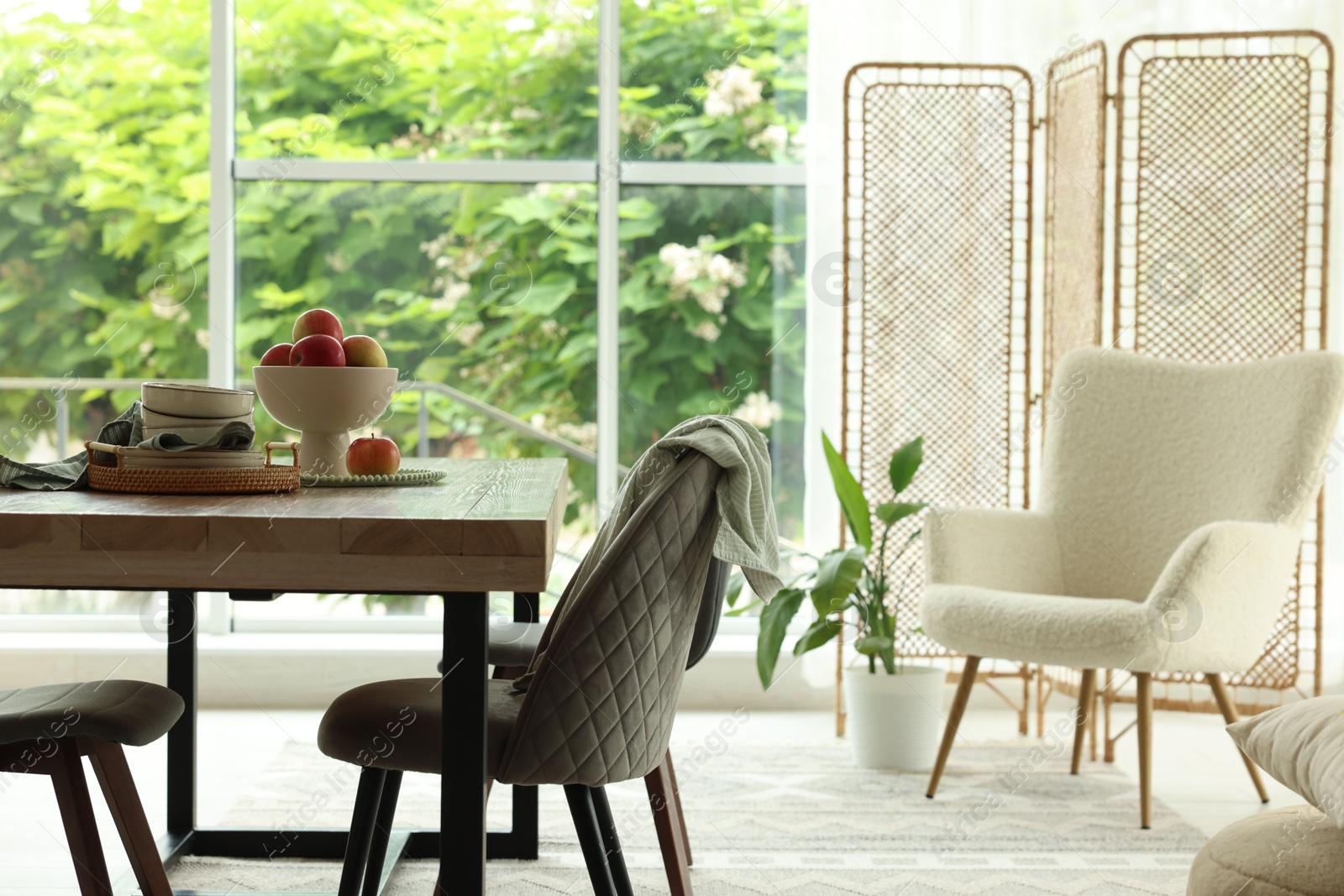 Wooden table, chairs, armchair and decor in dining room. Interior design Photo of Wooden table, chairs, armchair and decor in dining room. Interior design