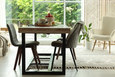 Photo of Wooden table, chairs, armchair and decor in dining room. Interior design