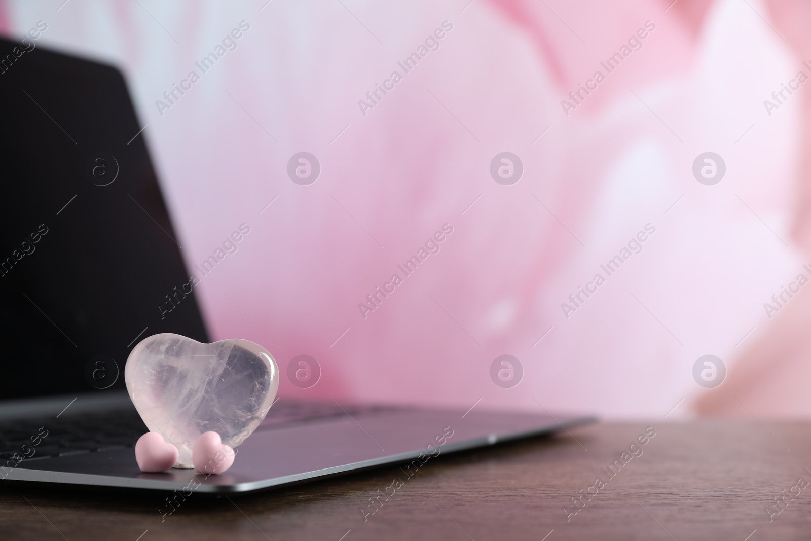Online dating site. Decorative hearts and laptop on wooden table, closeup. Space for text Photo of Online dating site. Decorative hearts and laptop on wooden table, closeup. Space for text