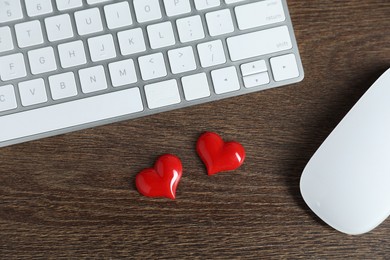 Photo of Decorative hearts, computer keyboard and mouse on wooden table, flat lay. Online dating site