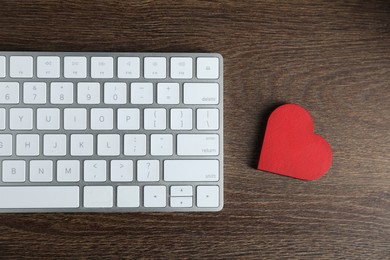 Photo of Decorative heart and computer keyboard on wooden table, flat lay. Online dating site