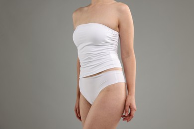 Photo of Woman in underwear on grey background, closeup