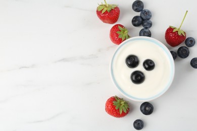 Photo of Tasty yoghurt with blueberries and strawberries in bowl on white marble table, flat lay. Space for text