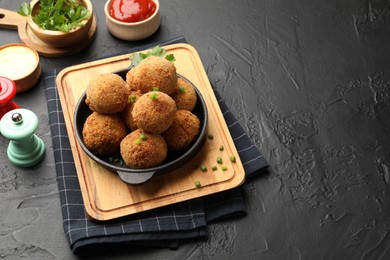 Photo of Delicious fried croquette balls with parsley and green onion on grey textured table. Space for text