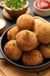 Photo of Delicious fried croquette balls with green onion on grey table, closeup