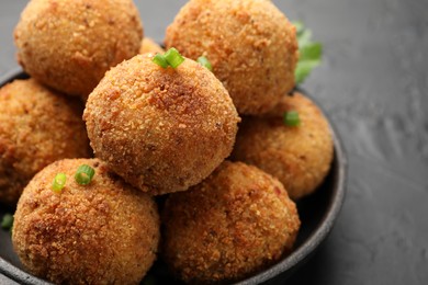 Photo of Delicious fried croquette balls with green onion on grey table, closeup