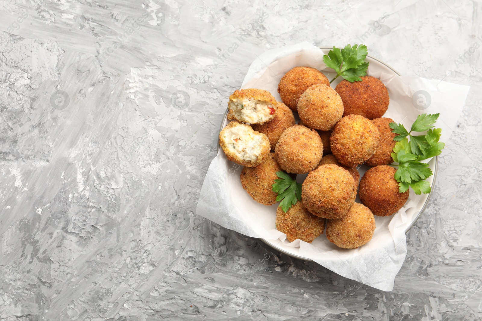 Delicious fried croquette balls with parsley on grey textured table, top view. Space for text Photo of Delicious fried croquette balls with parsley on grey textured table, top view. Space for text