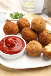 Photo of Delicious fried croquette balls with parsley and ketchup on table, closeup