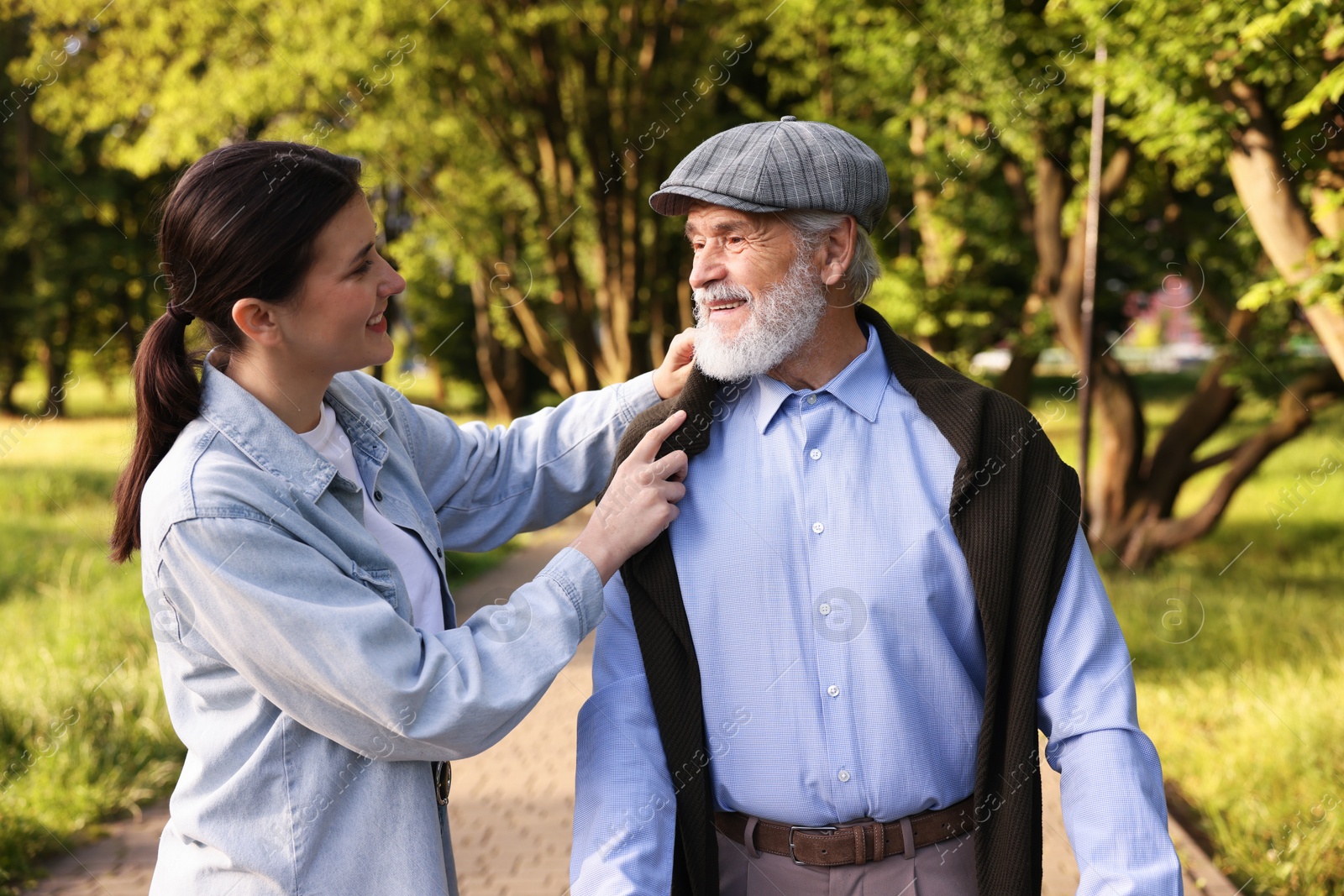 Smiling caregiver supporting elderly man in park Photo of Smiling caregiver supporting elderly man in park