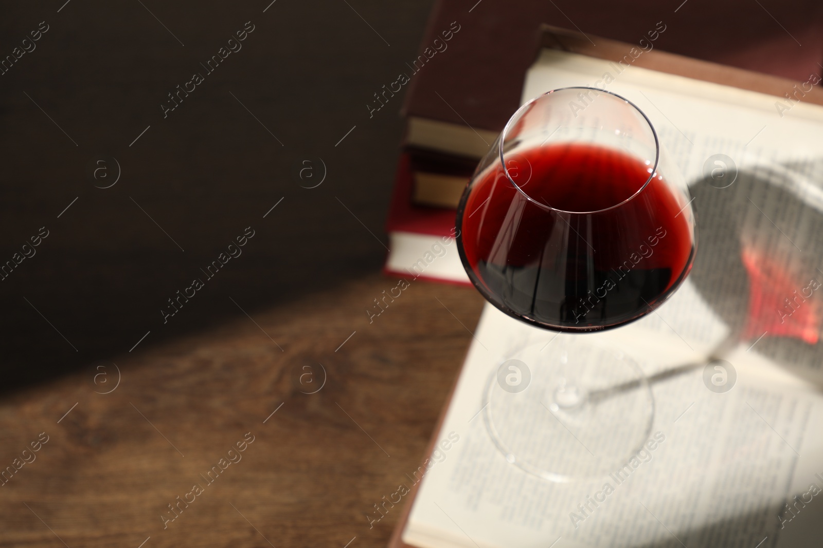 Glass of wine and books on wooden table. Space for text Photo of Glass of wine and books on wooden table. Space for text
