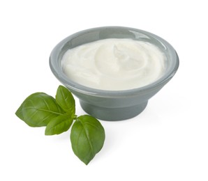 Photo of Tasty yoghurt in bowl and basil isolated on white