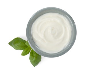 Photo of Tasty yoghurt in bowl and basil isolated on white, top view