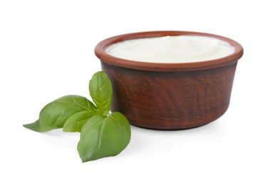 Photo of Tasty yoghurt in bowl and basil isolated on white
