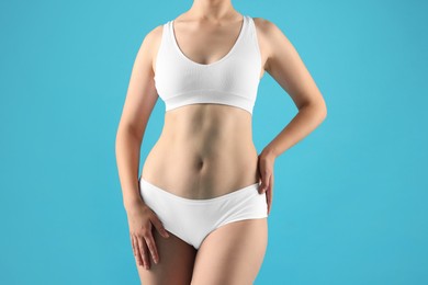 Photo of Woman in underwear on light blue background, closeup