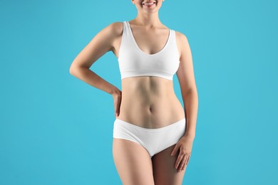Photo of Woman in underwear on light blue background, closeup