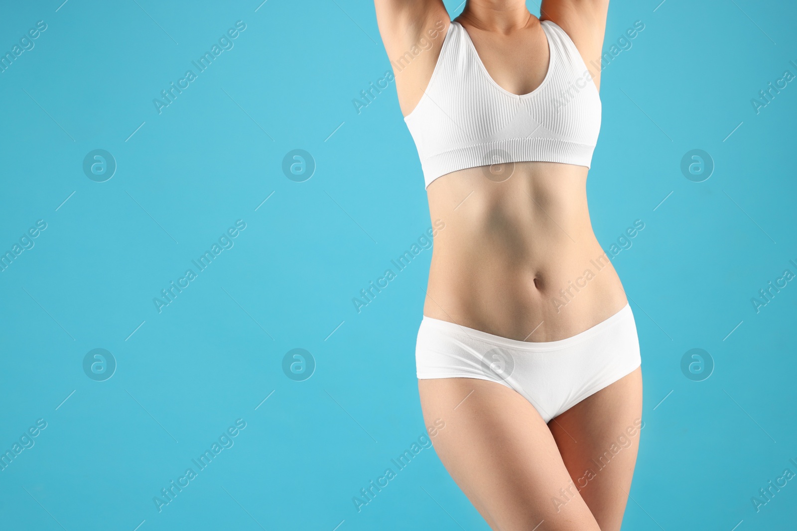 Woman in underwear on light blue background, closeup. Space for text Photo of Woman in underwear on light blue background, closeup. Space for text