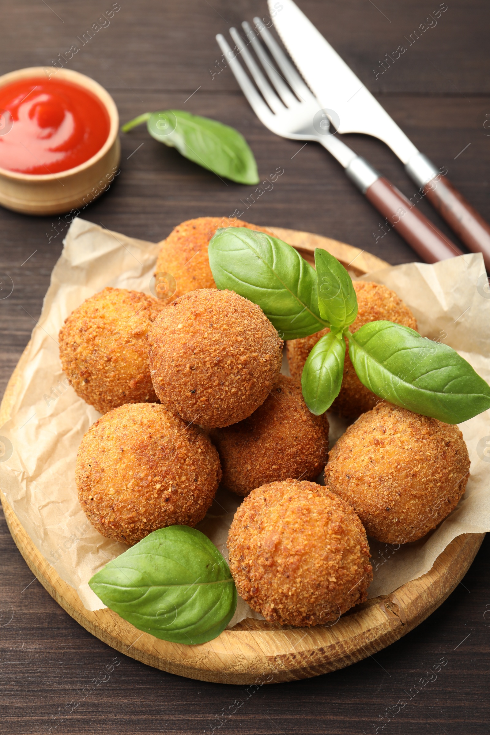 Delicious fried croquette balls with basil on wooden table, closeup Photo of Delicious fried croquette balls with basil on wooden table, closeup
